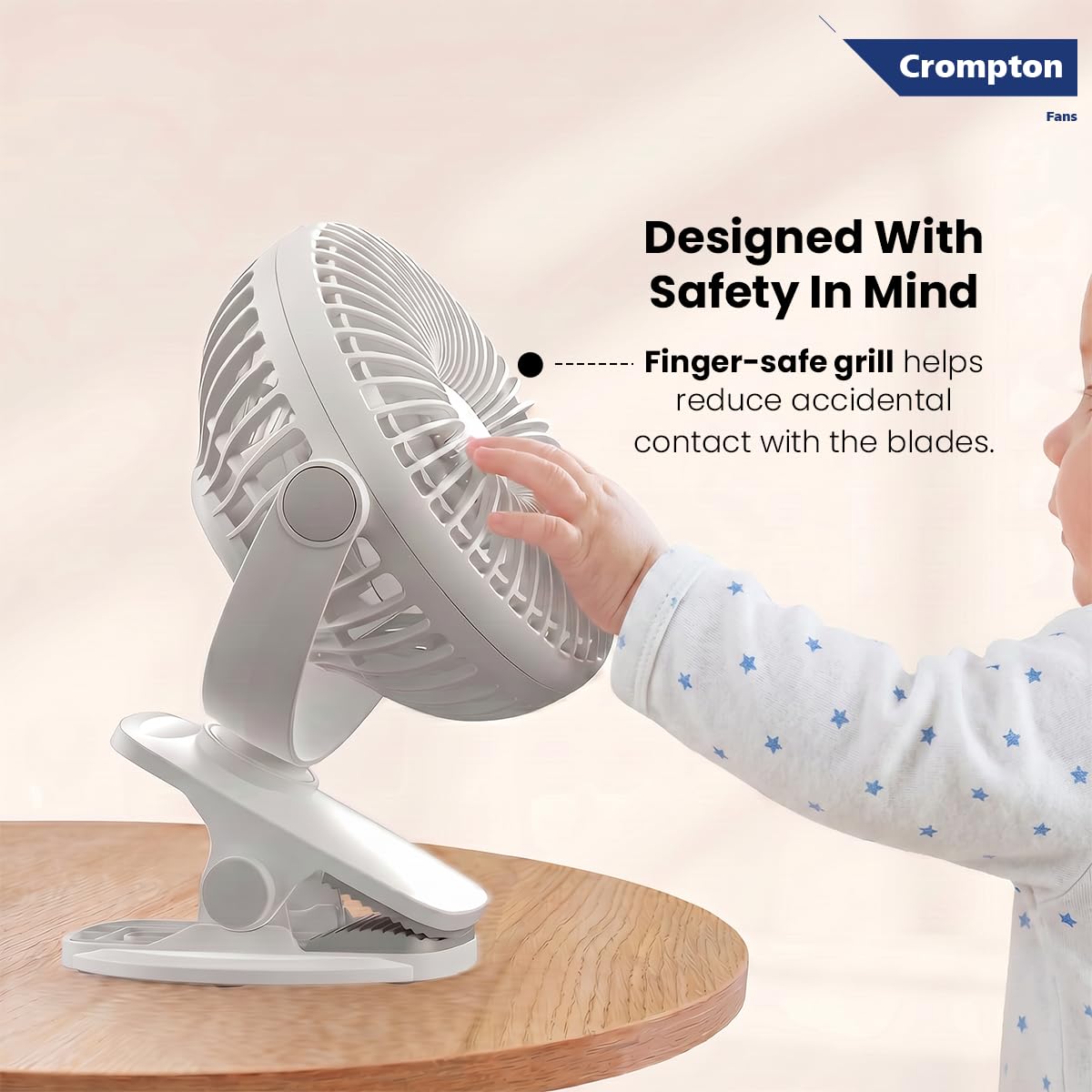 Crompton fan with a child's hand touching the safe grill design on a beige background