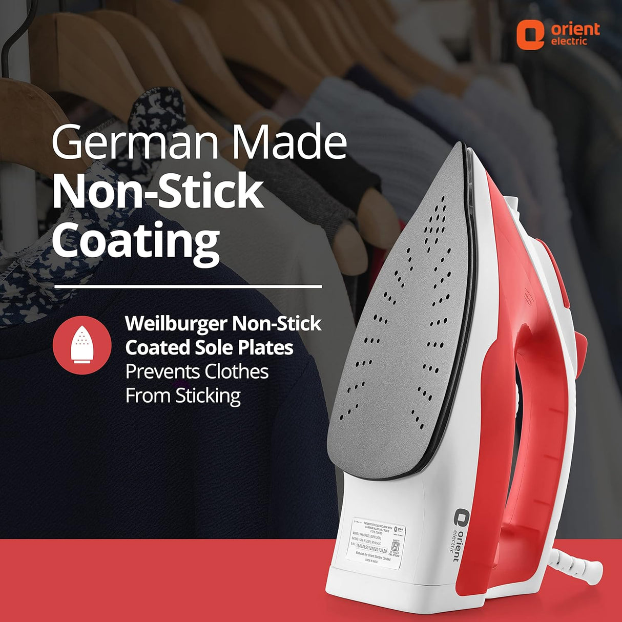 Red and white iron with German-made non-stick coating feature on a blurred background of clothes on hangers.