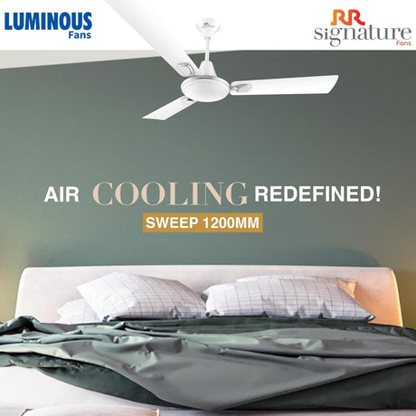 Ceiling fan above a bed with 'Luminous Fans' and 'RR Signature Fans' branding.