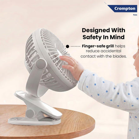 Crompton fan with a child's hand touching the safe grill design on a beige background