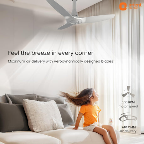 Orient Electric ceiling fan in a room with a child sitting on a couch, promoting maximum air delivery.