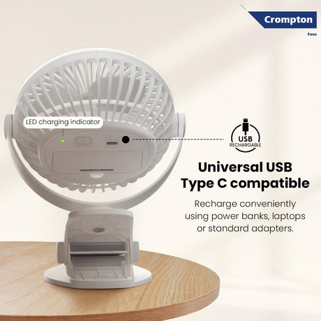 White portable fan with USB charging indicator on a wooden surface, featuring Crompton logo.