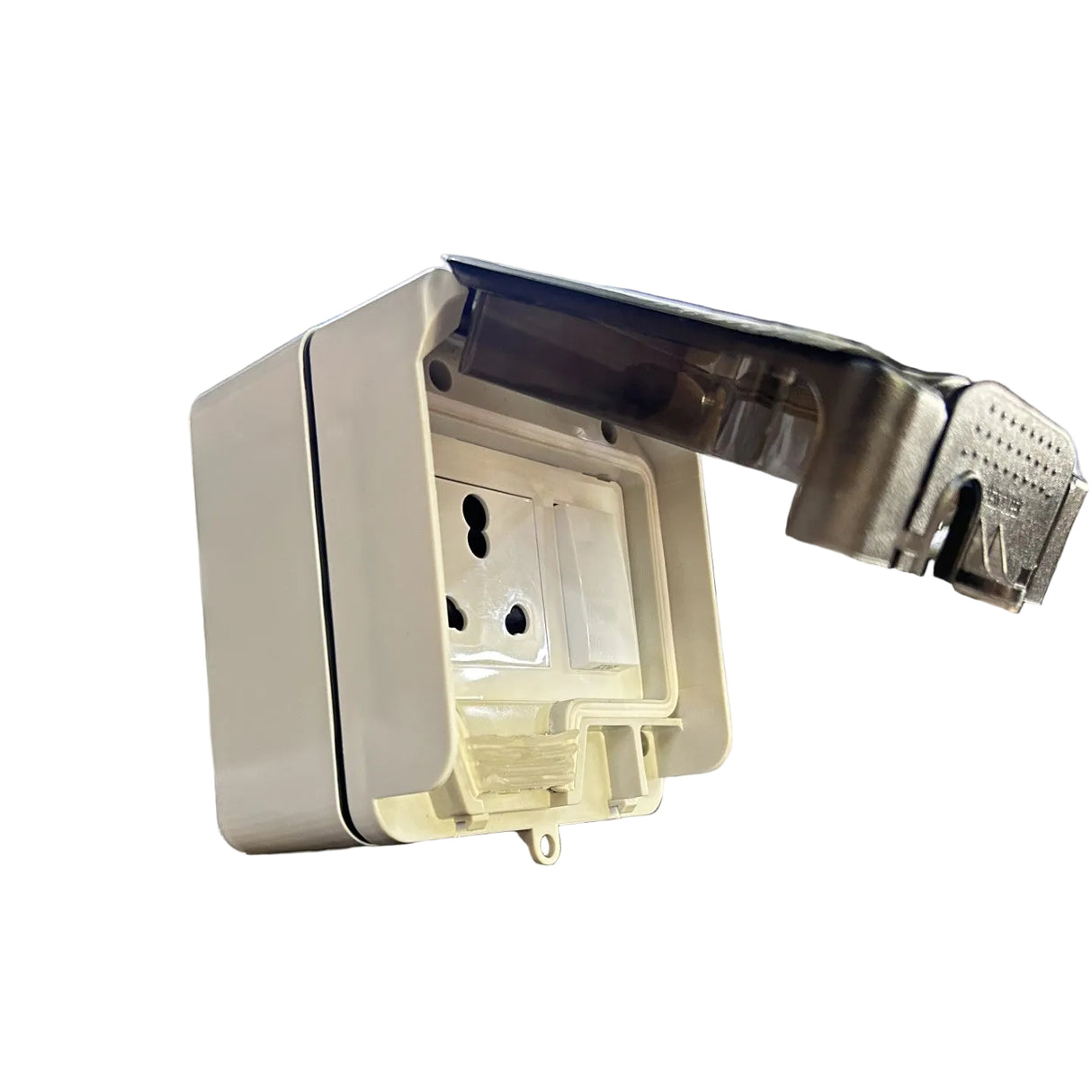 A white plastic wall outlet cover with a transparent protective flap open, resting on a retail display box in a warehouse or store setting with shelving and boxes in the background.