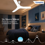 A Crompton ceiling fan in a modern children's bedroom, shown with a child sleeping under a blue starry comforter. The image includes marketing text highlighting the fan's silent operation and a sound decibel graph at the bottom.