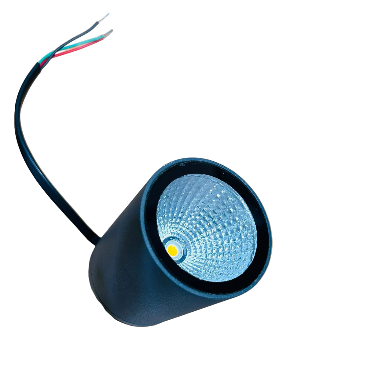 A black cylindrical LED light fixture with a textured silver reflector and a single wire with red, green, and black strands, placed on a wooden table.