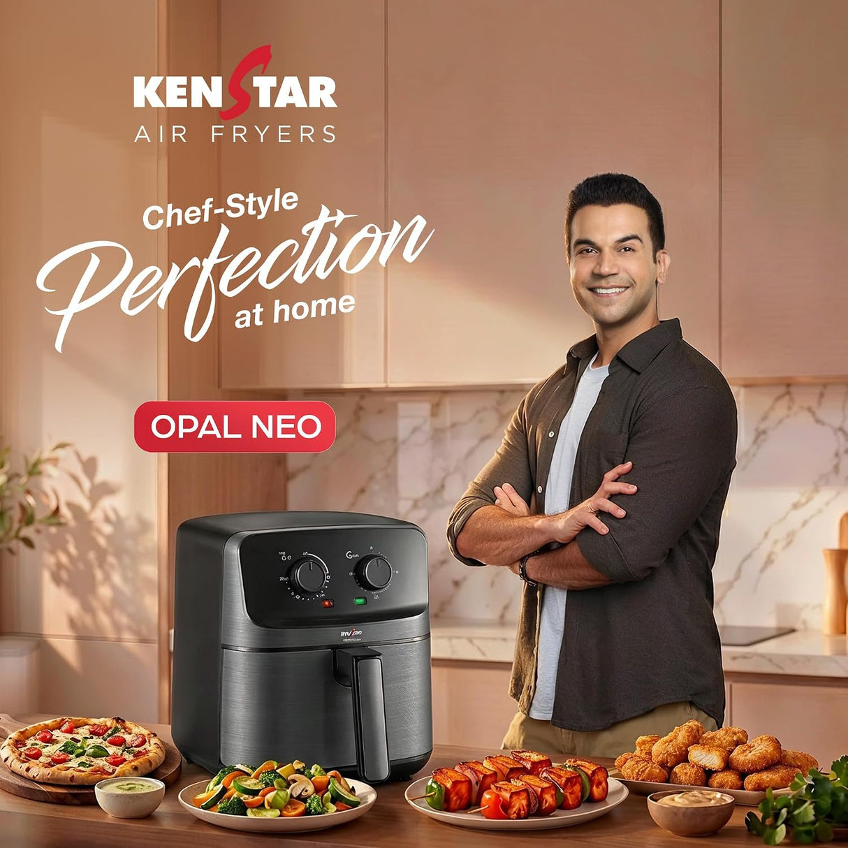 Ken Star Air Fryers Opal Neo air fryer in a modern kitchen setting, shown next to a smiling man in a dark shirt. Plates of prepared food are arranged on the counter, and promotional text for Ken Star Air Fryers and Opal Neo is displayed on the left.