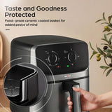 A KENSTAR air fryer in black and stainless steel, shown with a hand holding the handle and promotional text on a beige background with decorative olive branches.