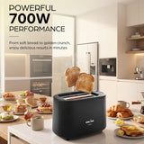 A black KUNFAV 2-slice toaster sits on a kitchen counter with two slices of toast popping out. The scene is set in a bright, modern kitchen with breakfast items on the counter, accompanied by promotional text highlighting 700W performance.
