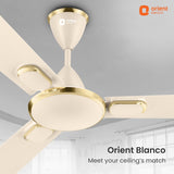 Ceiling fan with gold and beige design on a gray ceiling, featuring the Orient Electric logo.