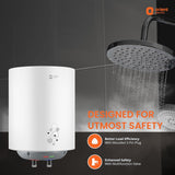 White water heater with shower head and 'Orient Electric' branding on a dark tiled wall background.