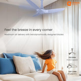 Ceiling fan in a room with a child sitting on a couch, featuring Orient Electric branding.