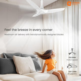 Ceiling fan in a room with a child sitting on a couch, featuring Orient Electric branding.
