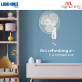 Wall-mounted fan on a blue wall with Luminous and RR Signature branding.