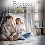 Two people sitting on the floor with a fan and 'Breeze' text indicating different breeze speeds.
