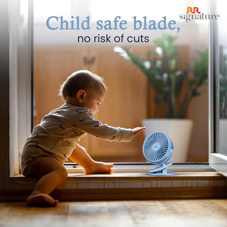 Child playing with a small fan near a window, with text about child-safe blades.
